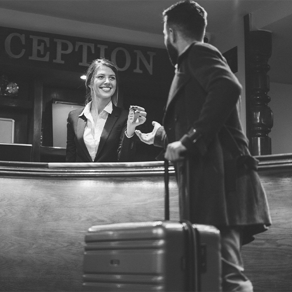 Hospitality employee granting hotel key to guest